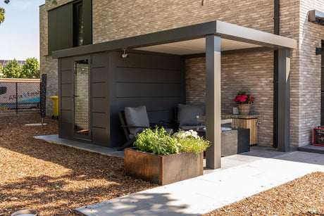 Modern outdoor pergola with shaded seating, planter, and brick backdrop for garden living