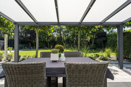 Modern outdoor dining under a sleek pergola with wicker chairs and lush garden views