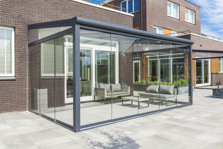 Modern glass veranda with outdoor seating, enhancing garden living comfort and elegance