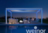Modern pergola with LED lights over outdoor seating by a pool at night, two people relaxing